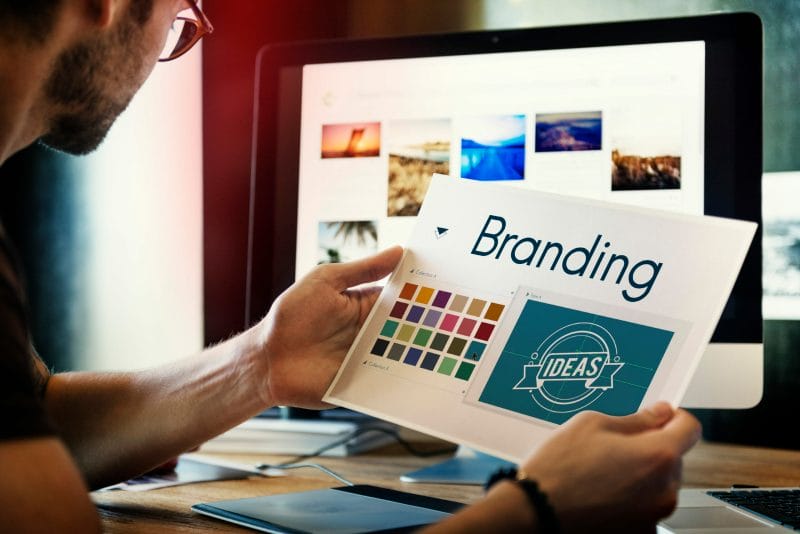 The Ultimate 2022 Guide to Law Firm Branding 1 Man holding paper with branding written on it